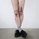 Abstract black tattoo on legs