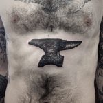 Black anvil tattoo on the belly