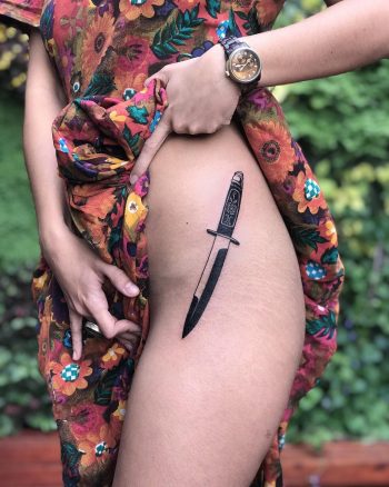 Black knife tattoo on the hip