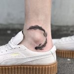 Black koi fish tattoo on the ankle