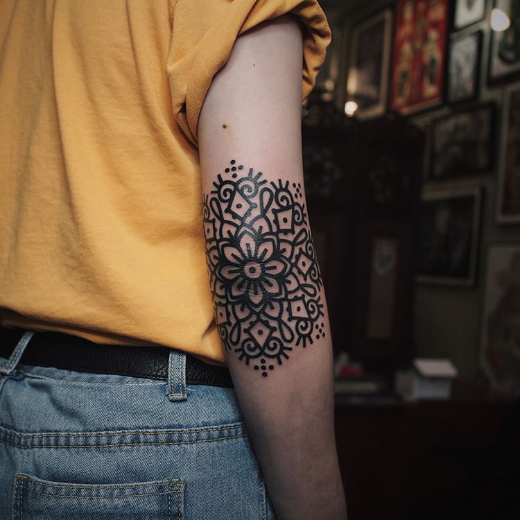 Black solid mandala tattoo on the elbow