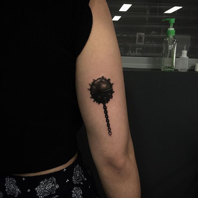 Black spiked flail tattoo