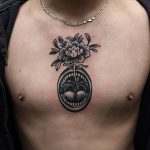 Black tattoo on the sternum and chest
