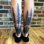 Black tree tattoos on calves