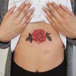 Colorful rose tattoo on the sternum