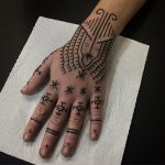 Cross and line tattoos on fingers