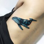 Double exposure whale and cosmic background tattoo