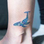 Floral blue whale tattoo