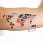 Floral world map tattoo on the bicep