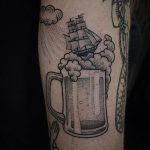 Glass of beer and a ship tattoo
