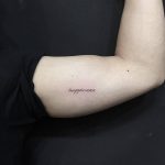Happiness tattoo on the bicep