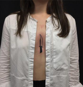 Knife tattoo on the sternum