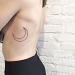 Linear crescent moon tattoo on the rib