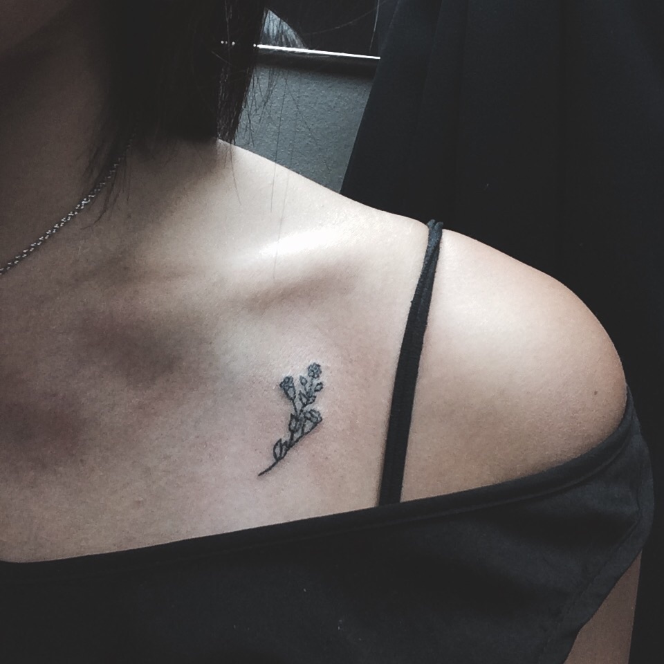 Little flower tattoo on the collarbone