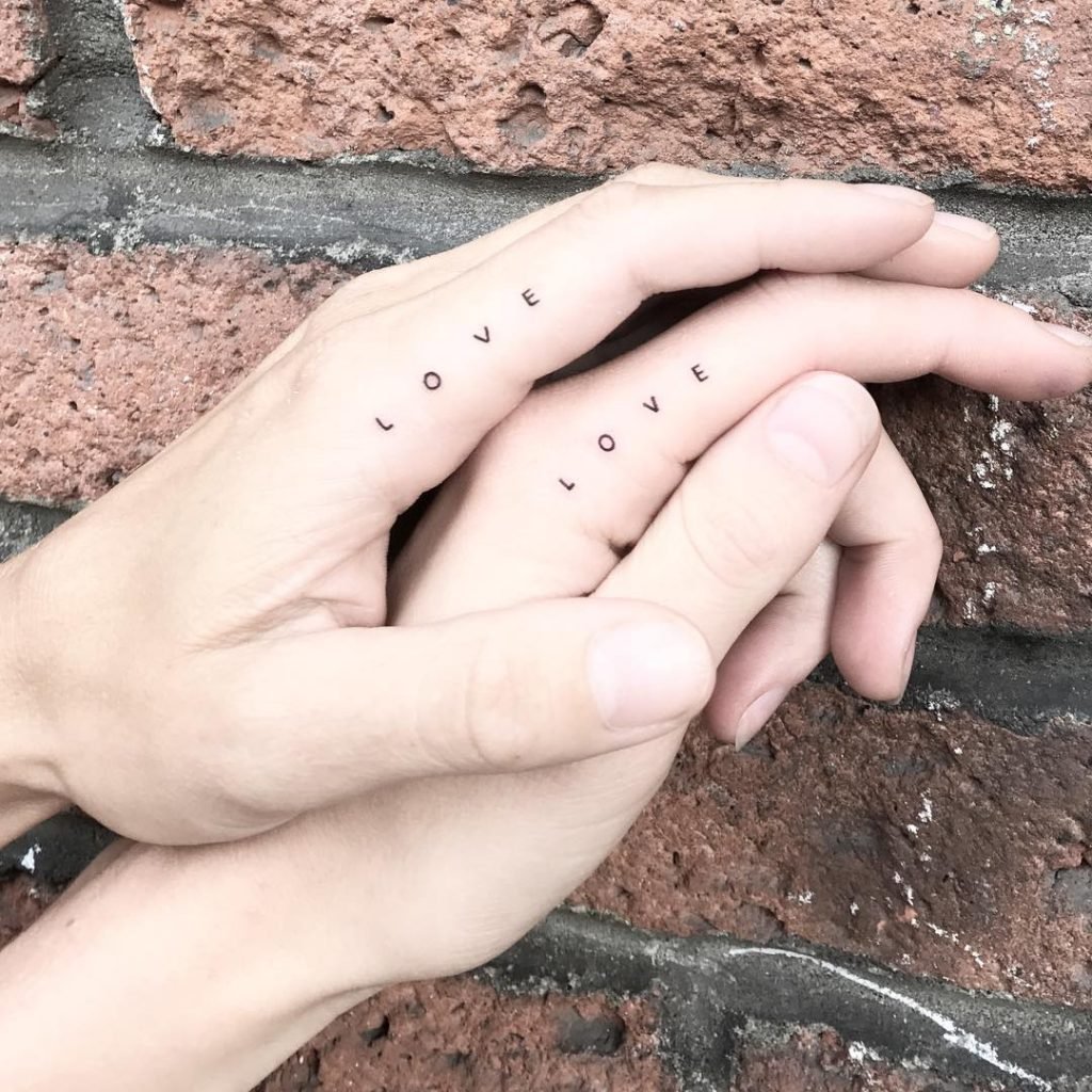Matching tiny heart tattoos on fingers