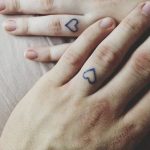 Matching small heart tattoos on fingers