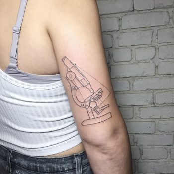 Microscope tattoo on the right upper arm