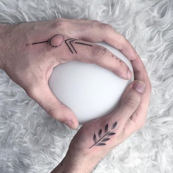 Minimal tattoos on both thumbs