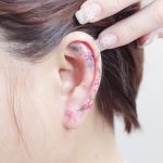 Minimalist flower tattoos on the left ear