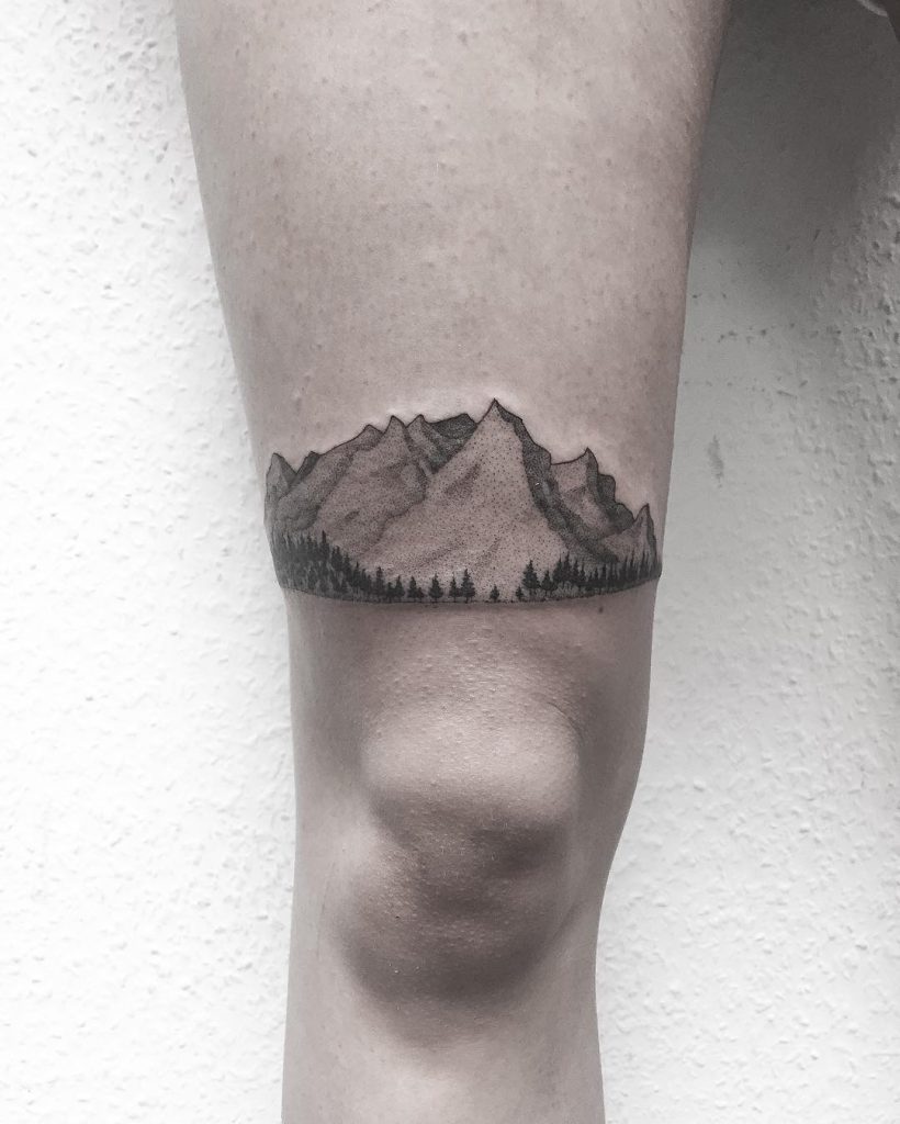 Mountains and trees tattoo on thigh