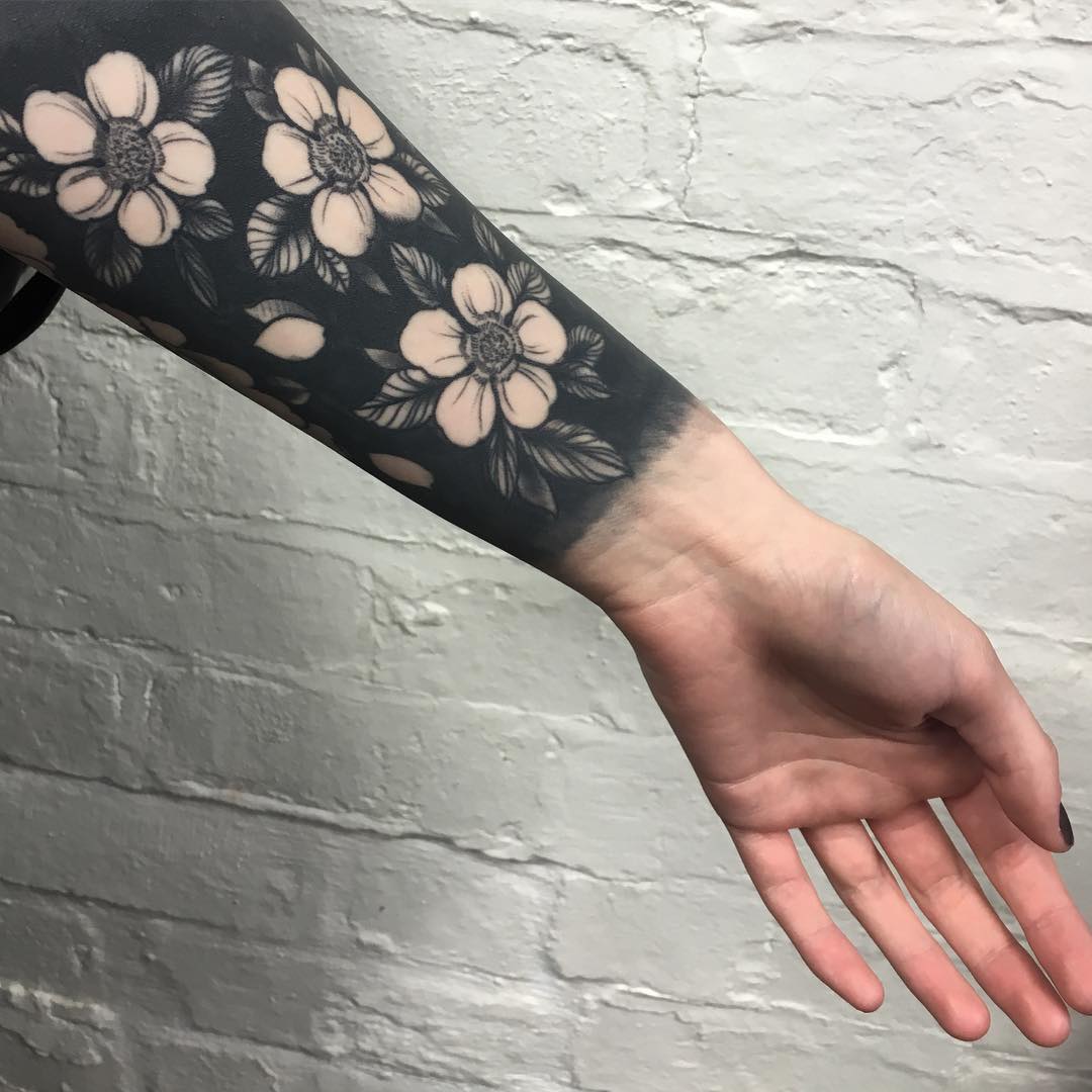 Negative space black flowers tattoo