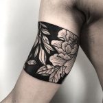 Negative space floral armband tattoo