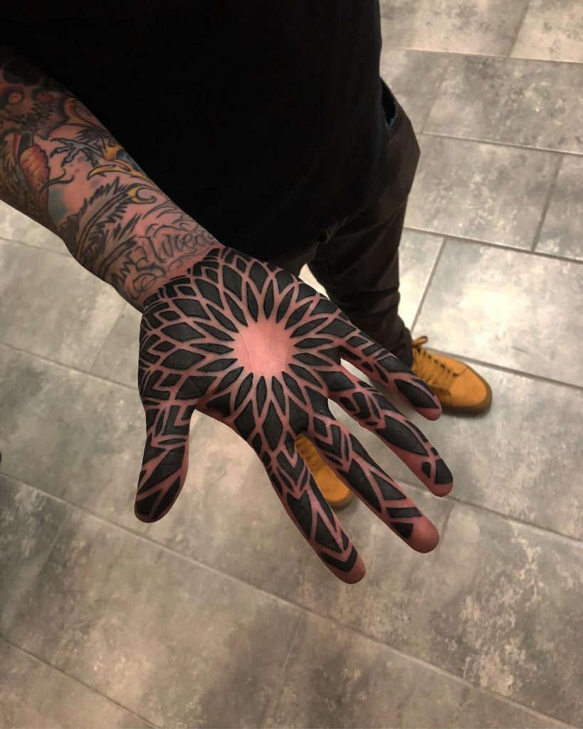 Negative space ornament tattoo on the palm