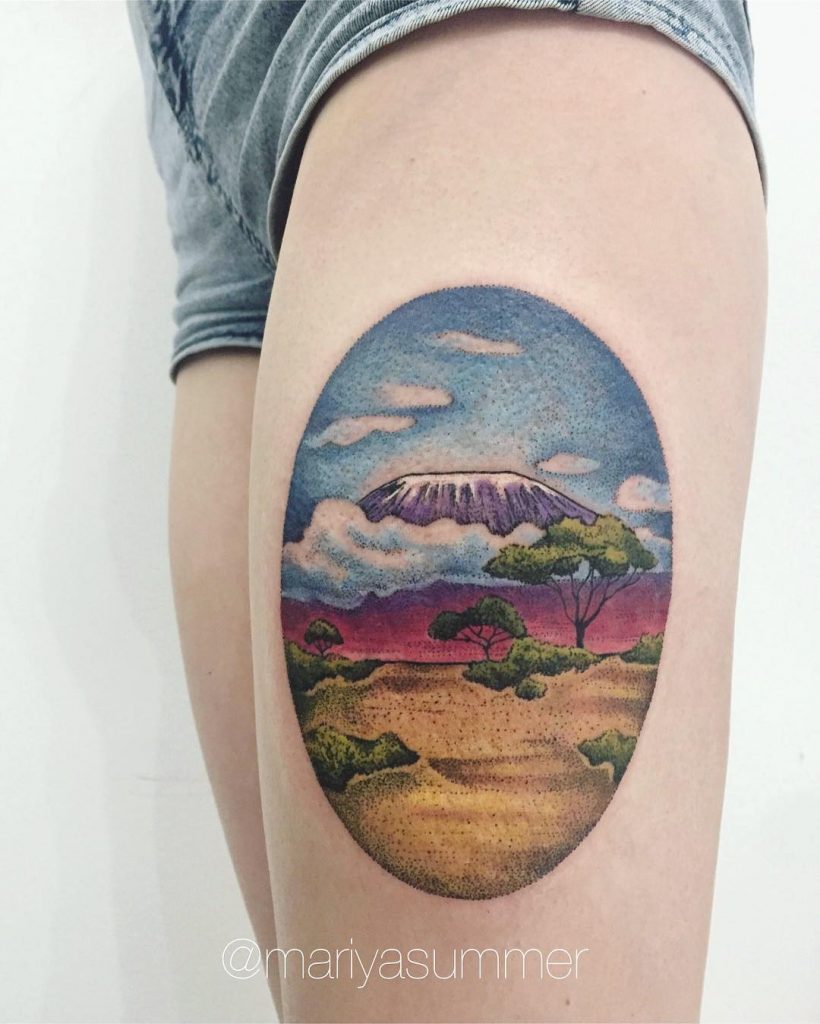 Oval landscape tattoo on the thigh