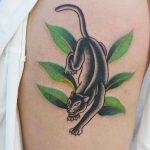 Panther and green leaves tattoo