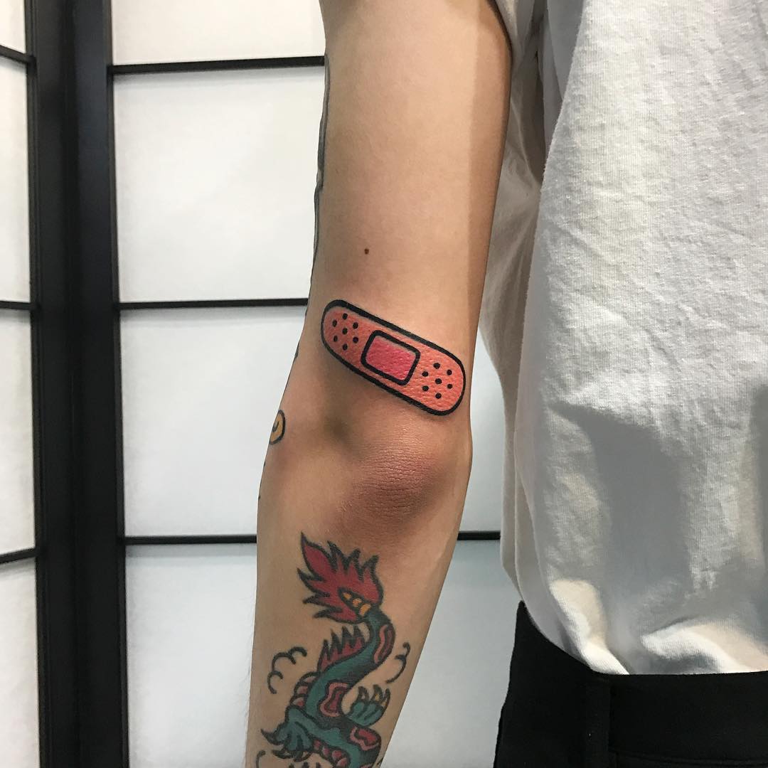 Pink band aid tattoo