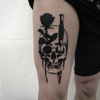 Rose and dagger stabbed skull tattoo