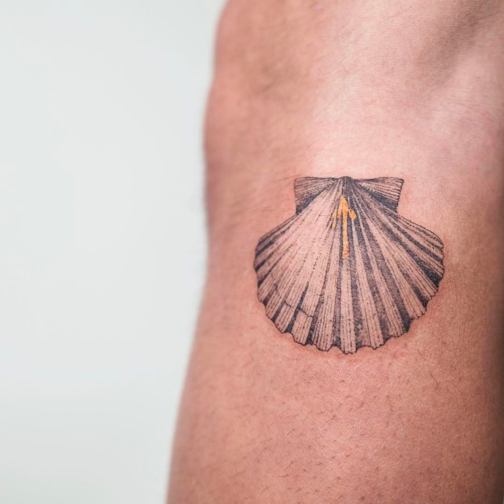 Scallop and yellow arrow tattoo