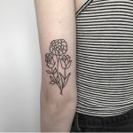 Simple flower tattoo on the back of the arm