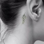 Small green twig tattoo behind the ear