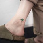 Subtle palm tree tattoo on the ankle