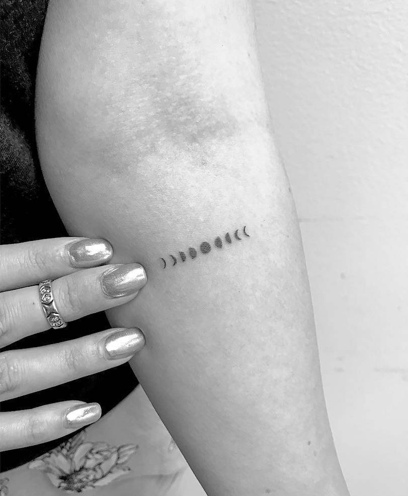 Tiny moon phases tattoo on the forearm 