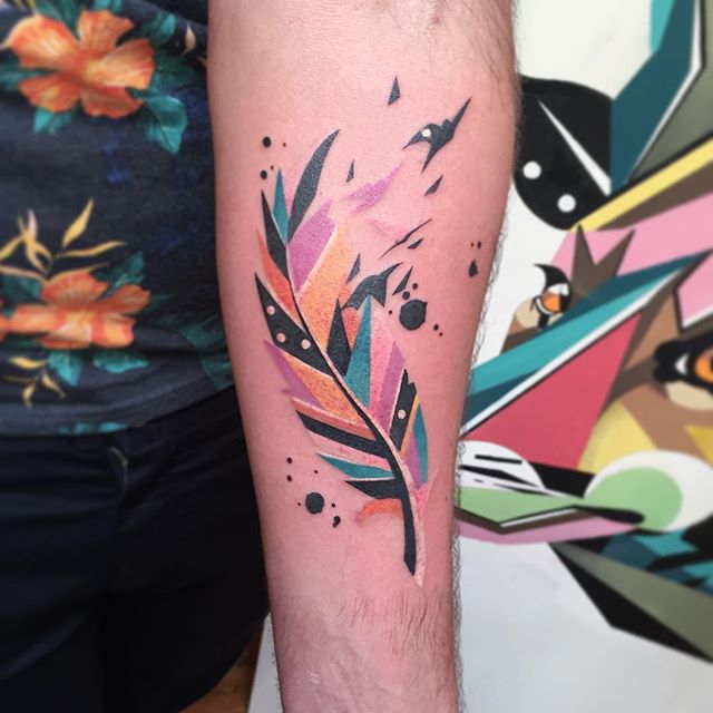 Watercolor feather tattoo on the forearm