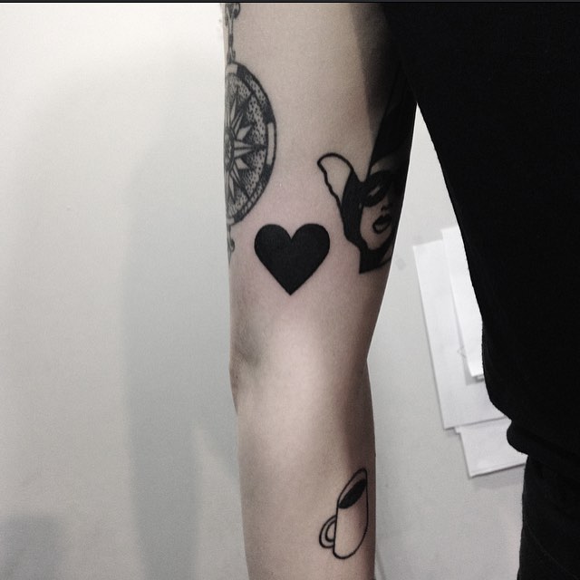 Black heart tattoo on the arm