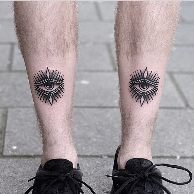 Black eye tattoos by jonas on shins