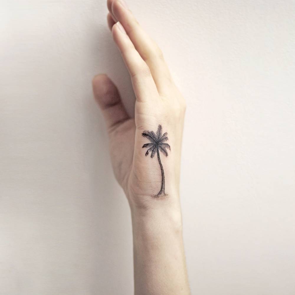 Black palm tree tattoo on the hand