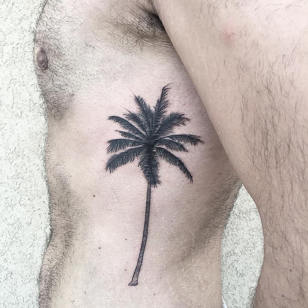 Black palm tree tattoo on the rib