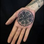 Black snowflake tattoo on the palm