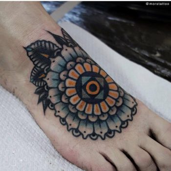 Blue and yellow mandala tattoo on the foot