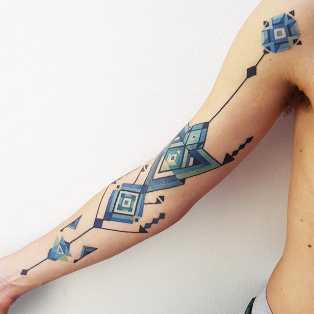 Blue geometric pattern tattoo on the right arm