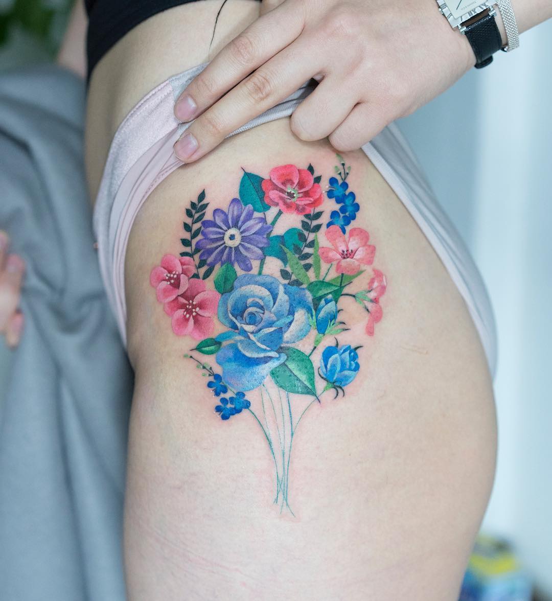 Colorful flower bouquet tattoo on the hip.