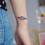 Colorful saturn tattoo on the wrist