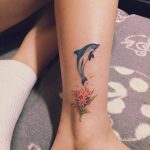 Dolphin and flower tattoo on the calf