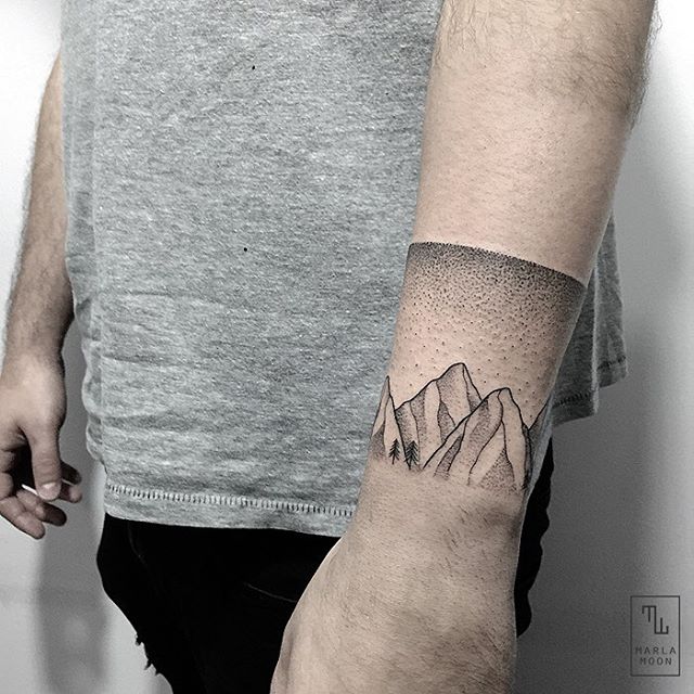 Abstract armband tattoo on the left forearm.