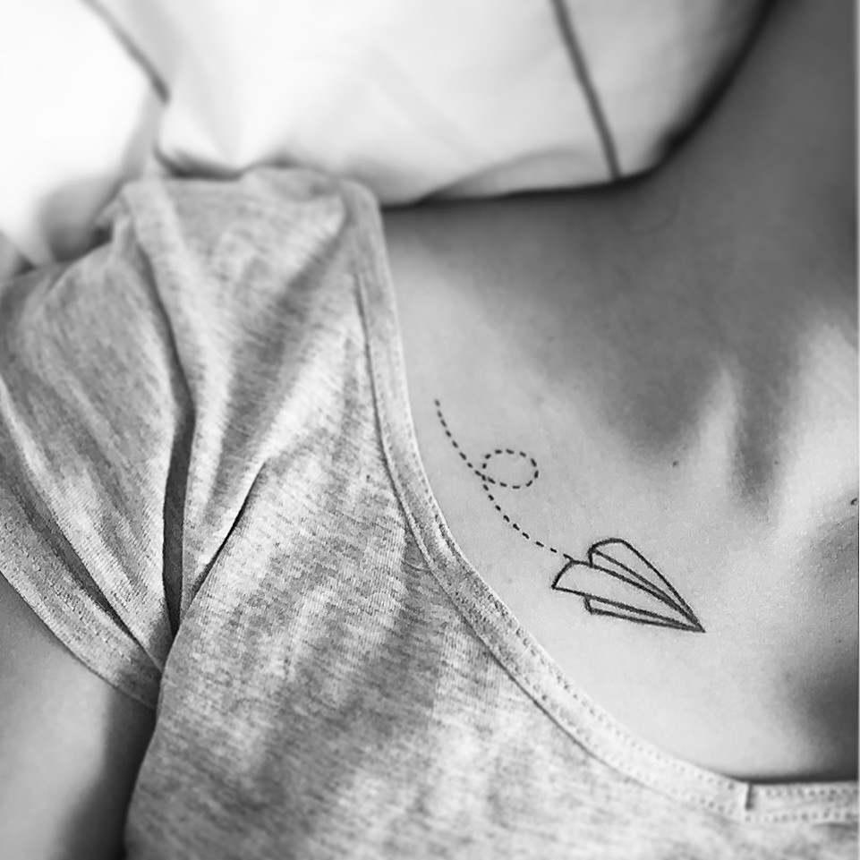 Flying paper plane tattoo on the clavicle bone