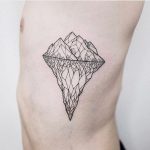 Geometric iceberg tattoo on the rib cage